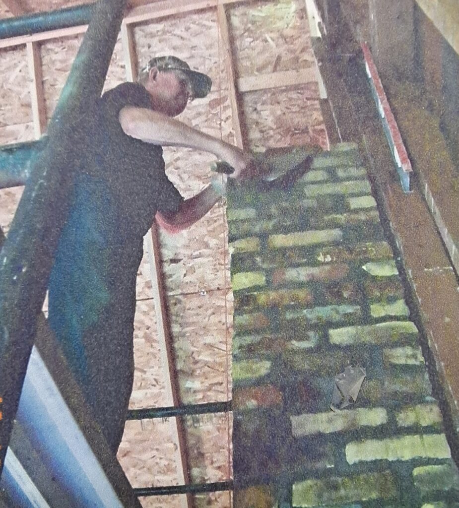 Laying bricks for the rebuilt chimney.